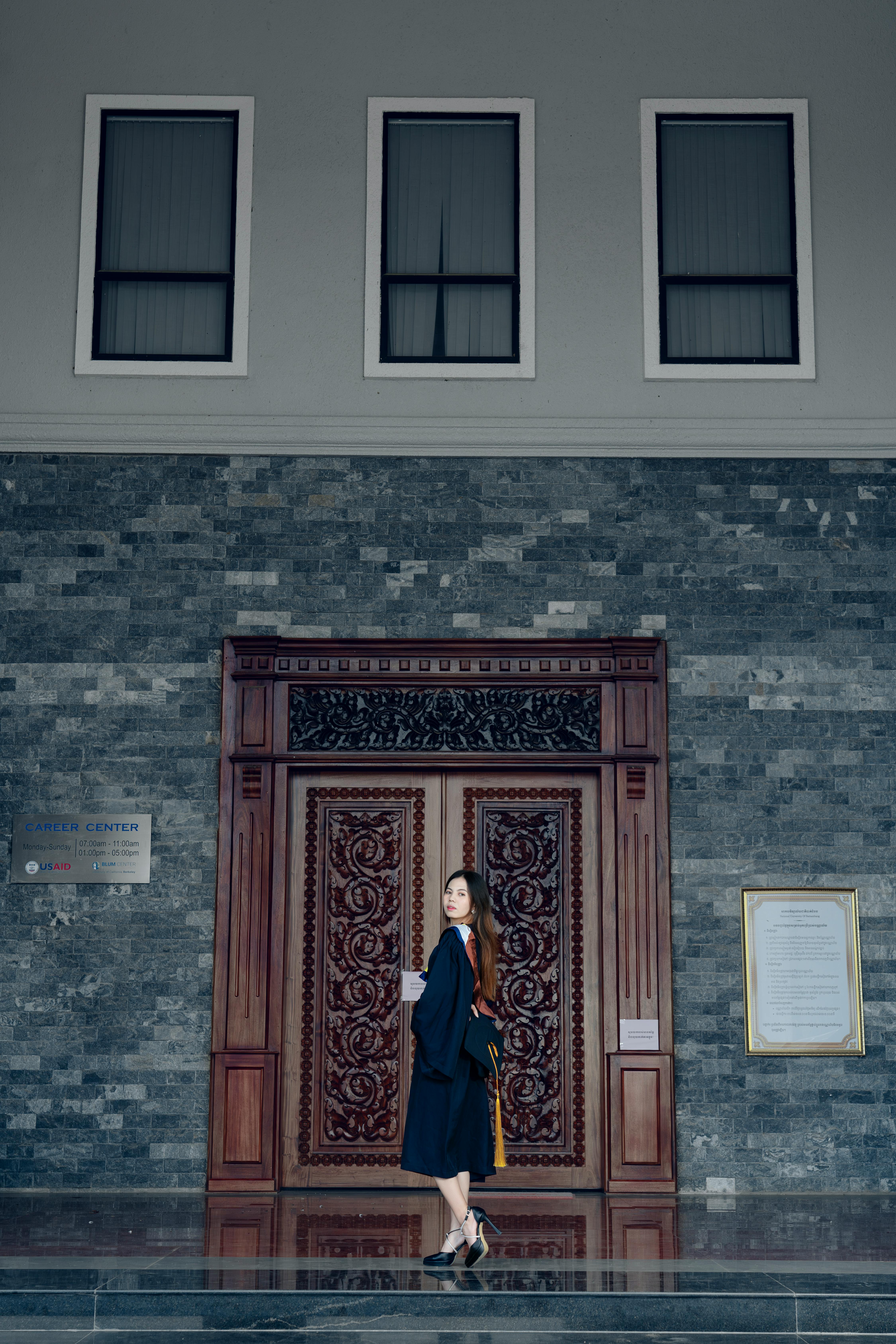 a woman standing in front of a large wooden door