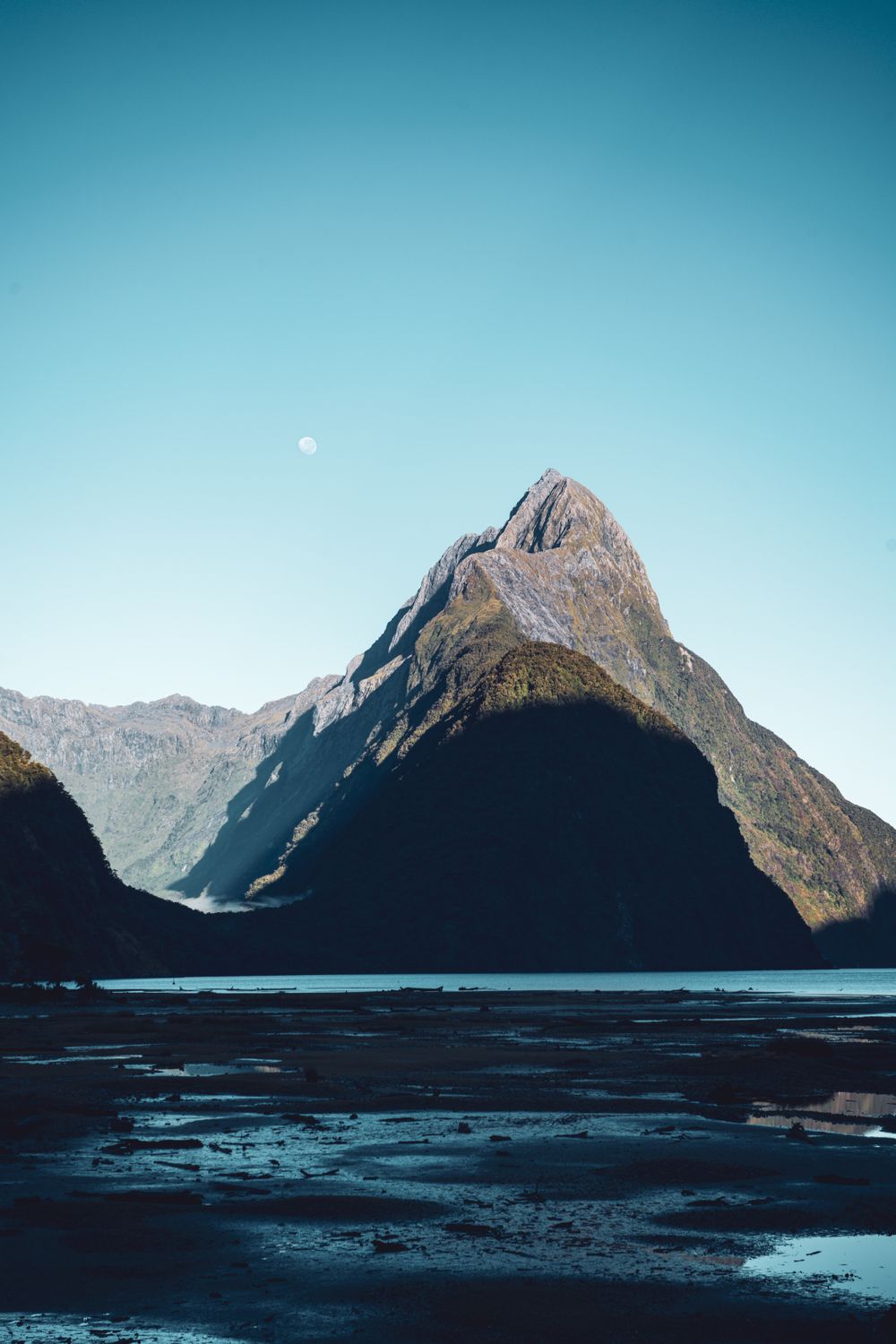 Mitre Peak en Milford Sound al crepúsculo con la luna apenas asomada