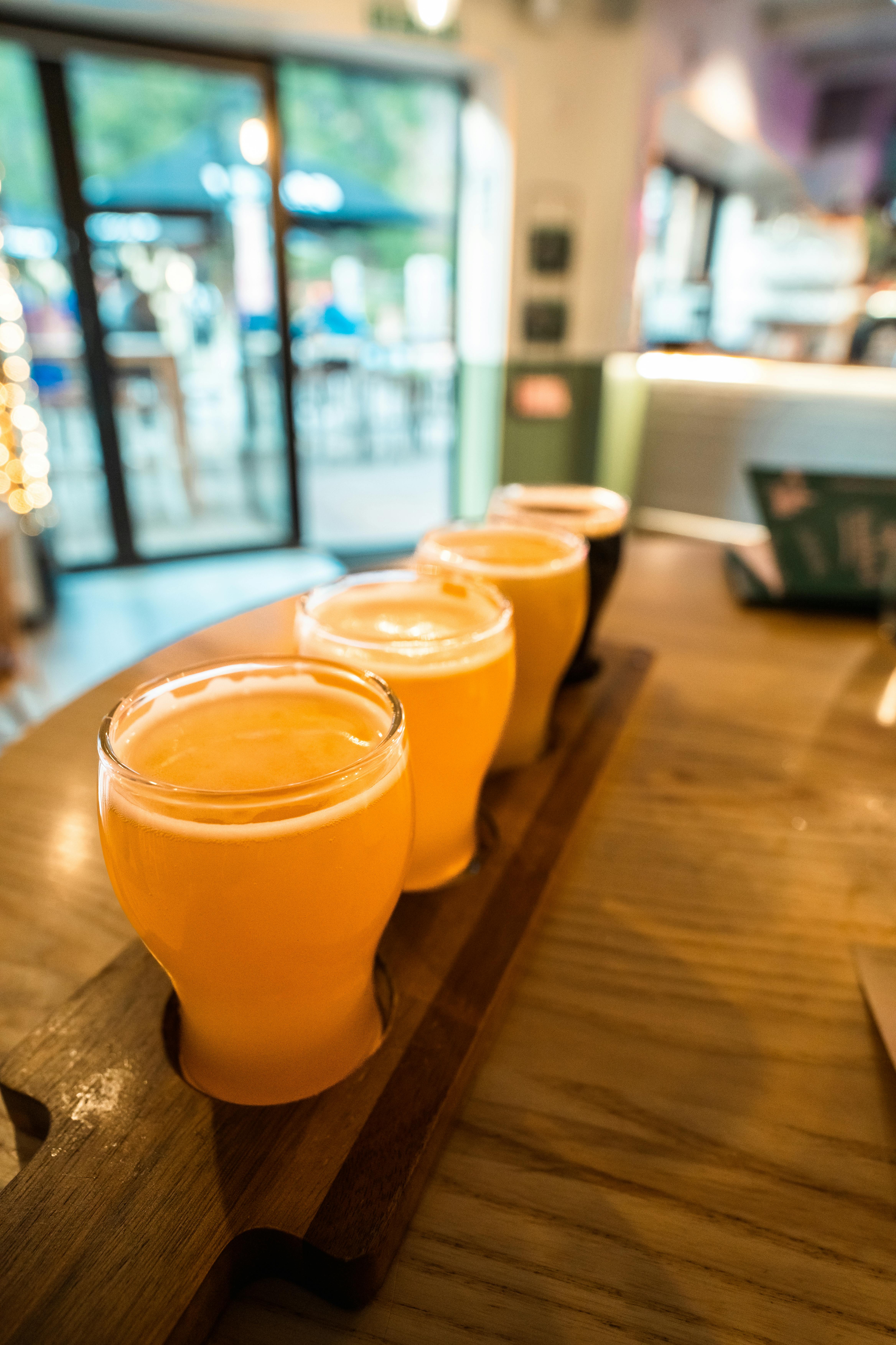 a wooden tray with four beers on it