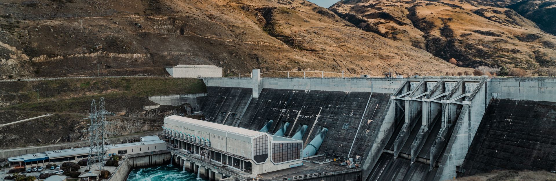 Powerful hydroelectric dam nestled in a rugged mountain landscape with clear blue waters.