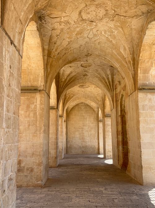 Free A narrow, ancient stone hallway with gothic arches, perfect for travel and architecture enthusiasts. Stock Photo