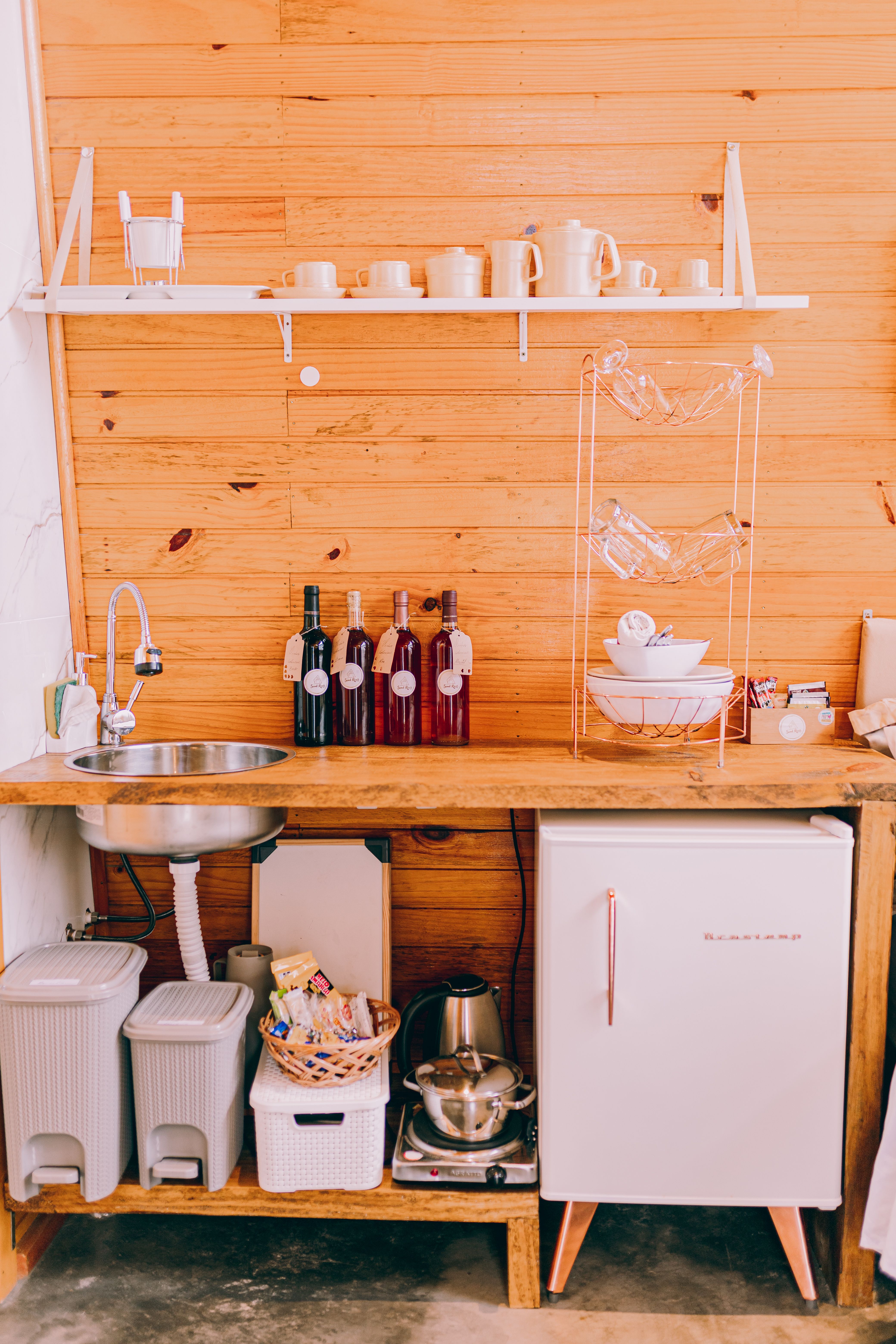 small corner coffee bar with an under counter mini fridge for storing coffee supplies
