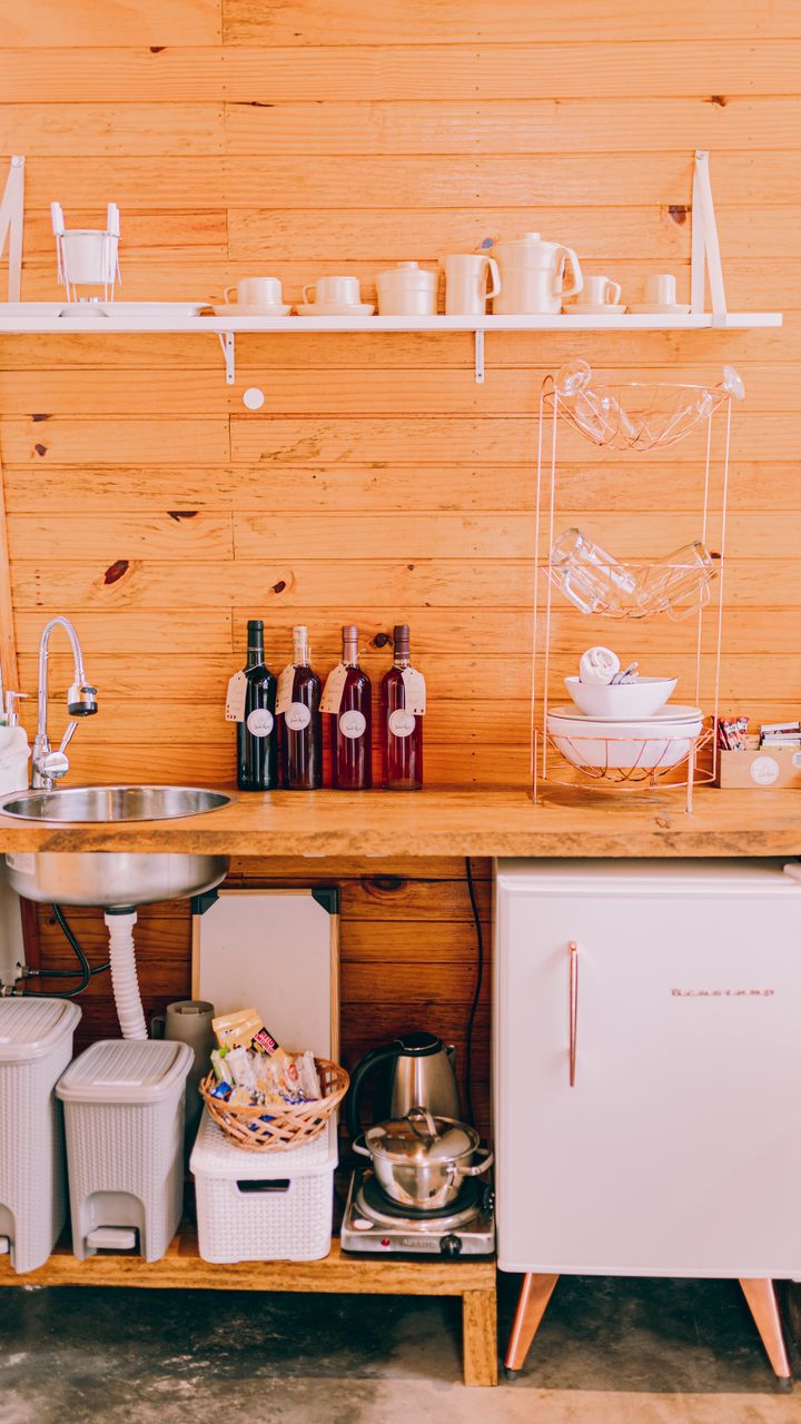 small corner coffee bar with an under counter mini fridge for storing coffee supplies