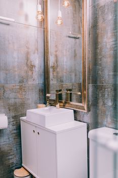 Stylish modern bathroom interior featuring a sleek sink and elegant mirror with warm lighting.