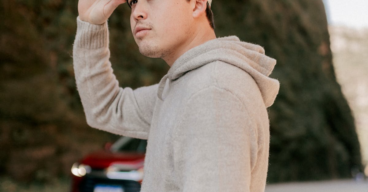 A man wearing a hoodie and holding a virtual reality headset
