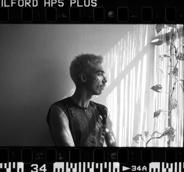 Artistic film portrait of a man by a window in León, Mexico.