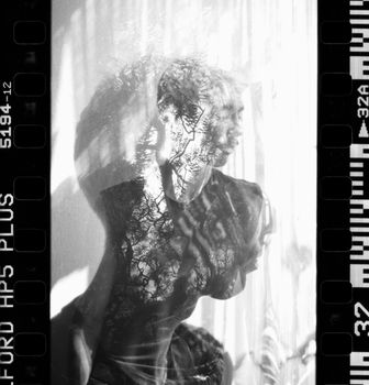 A creative double exposure portrait combining nature and a young man in black and white.