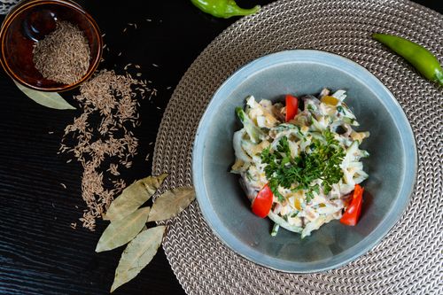 Free Fresh herb salad with tomatoes, cumin seeds, and spices on a woven mat. Stock Photo