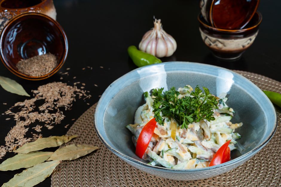 Delicious vegetable salad garnished with fresh herbs and served in a ceramic bowl.
