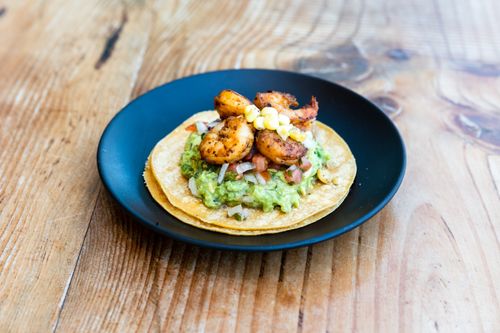 Free Delicious shrimp tacos with fresh guacamole and corn served on a rustic wooden table. Stock Photo