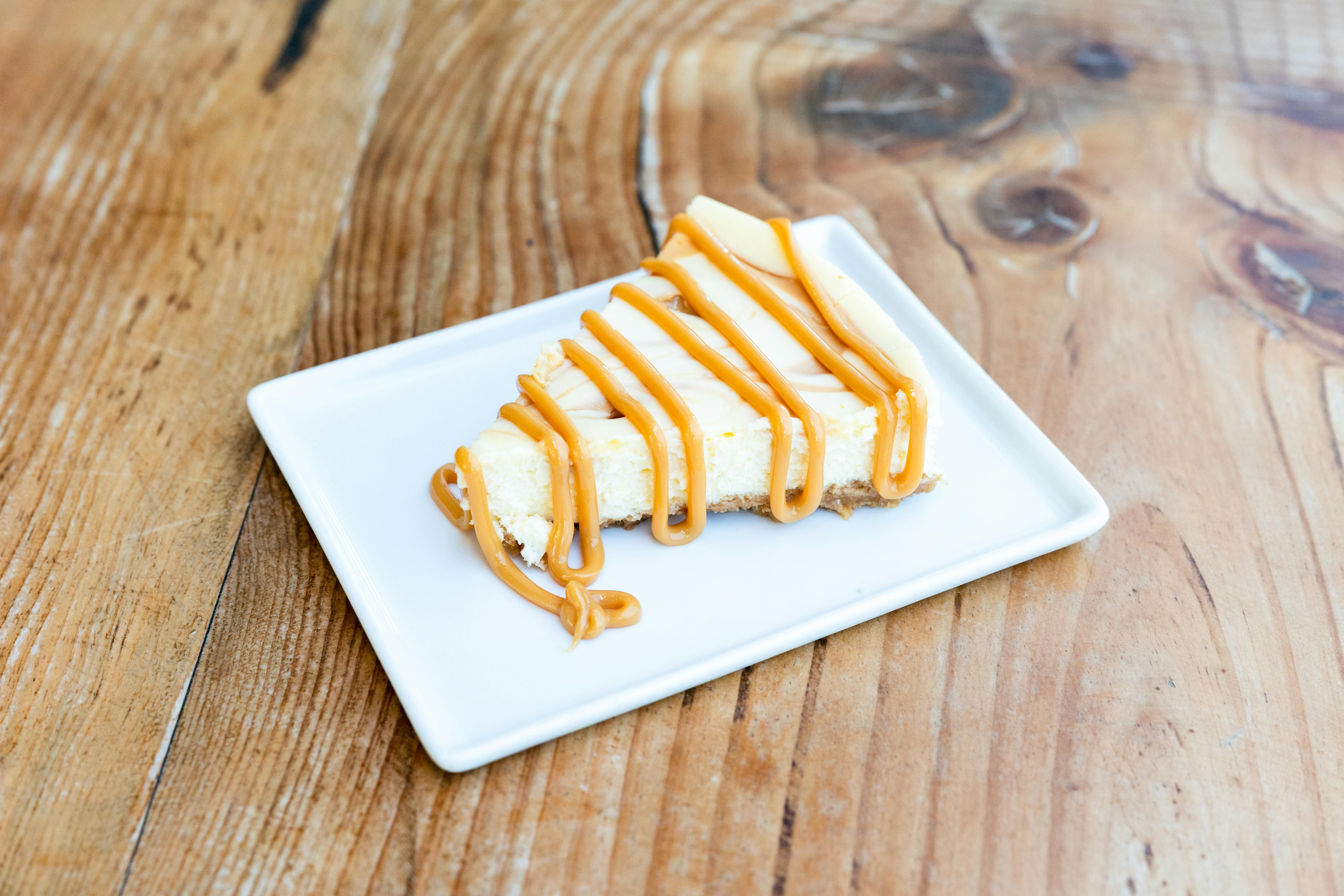 iced caramel latte recipe - Close-up of a delicious cheesecake slice drizzled with caramel, perfect for dessert lovers.