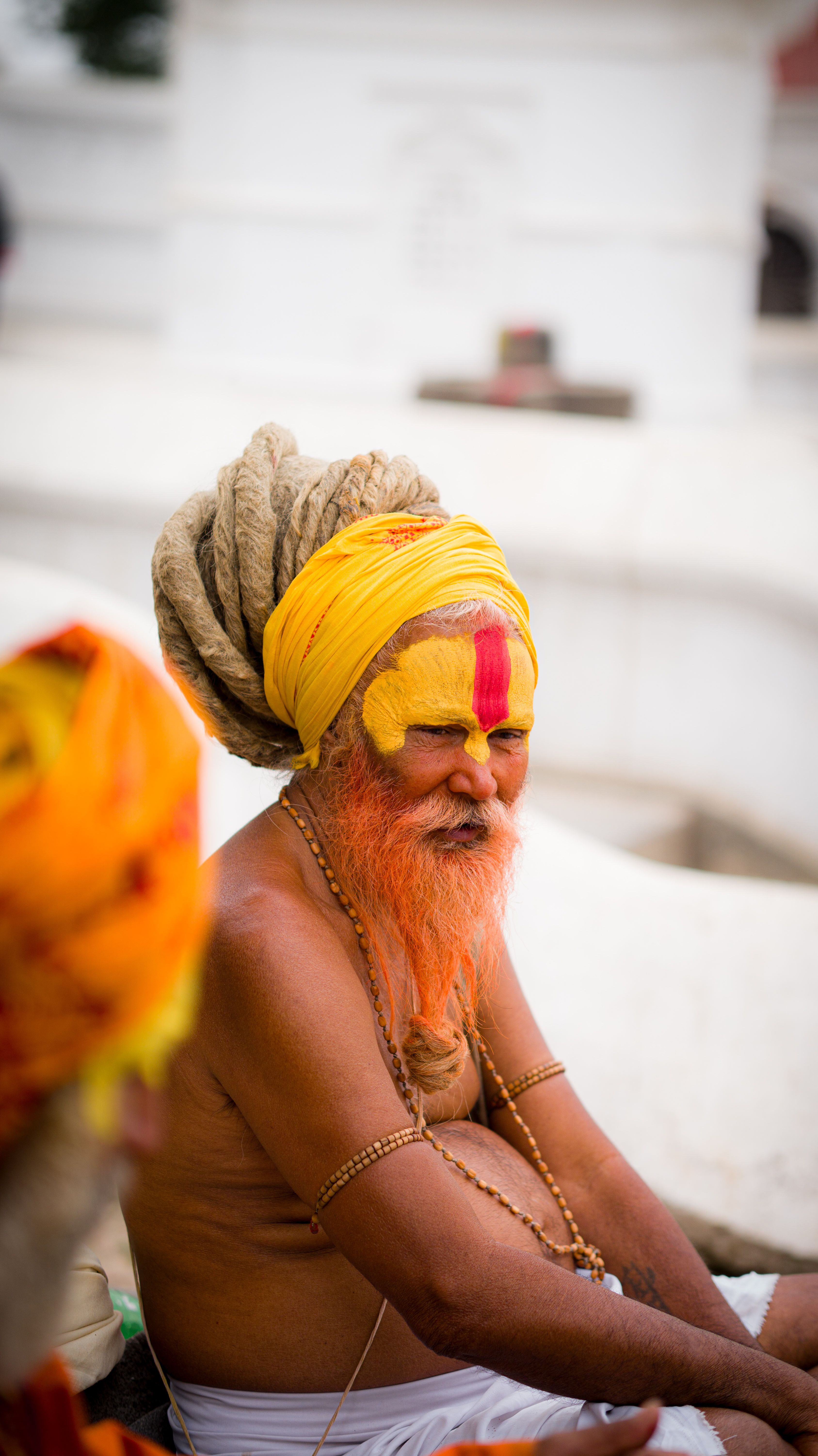 A Sadhu with traditional face paint and turban sitting at Pashupatinath Temple in Kathmandu, Nepal.
