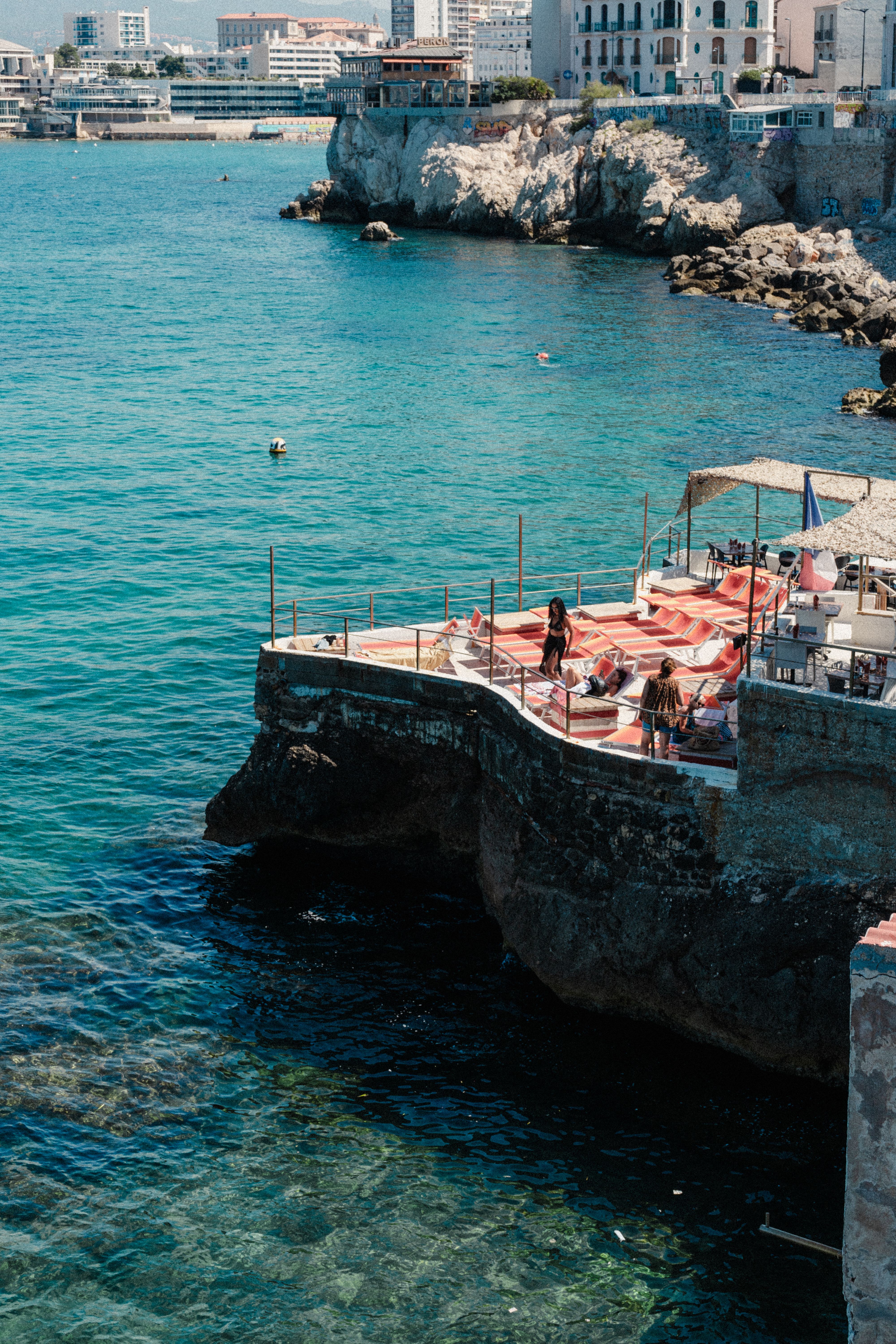 A view of the ocean and a restaurant on the rocks · Free Stock Photo