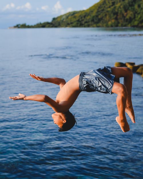 Free Dynamic shot of a boy diving into the sea in West Sulawesi, Indonesia. Perfect summer fun. Stock Photo