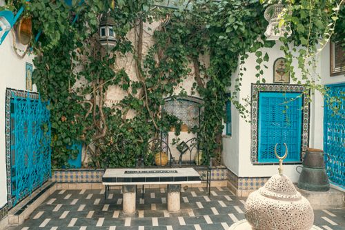 Free Serene Tunisian courtyard featuring vibrant blue accents and lush greenery. Stock Photo