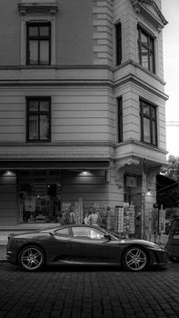 A vintage car parked by a classic building in Hamburg, Germany, showcasing architectural charm.