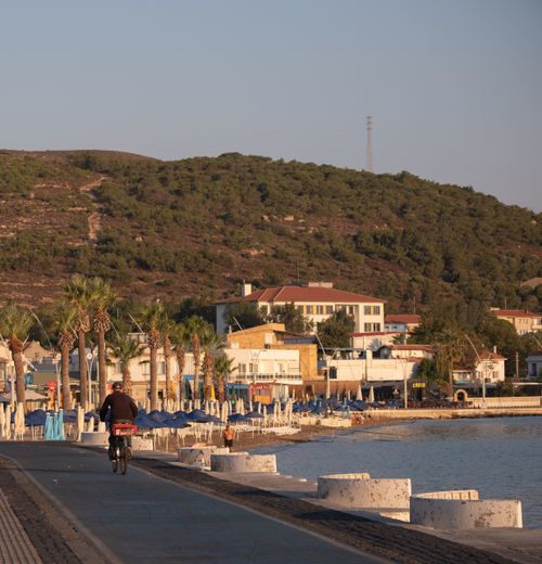Free Beautiful seaside view in Foça, İzmir, Türkiye with a cyclist on a coastal road during sunset. Stock Photo