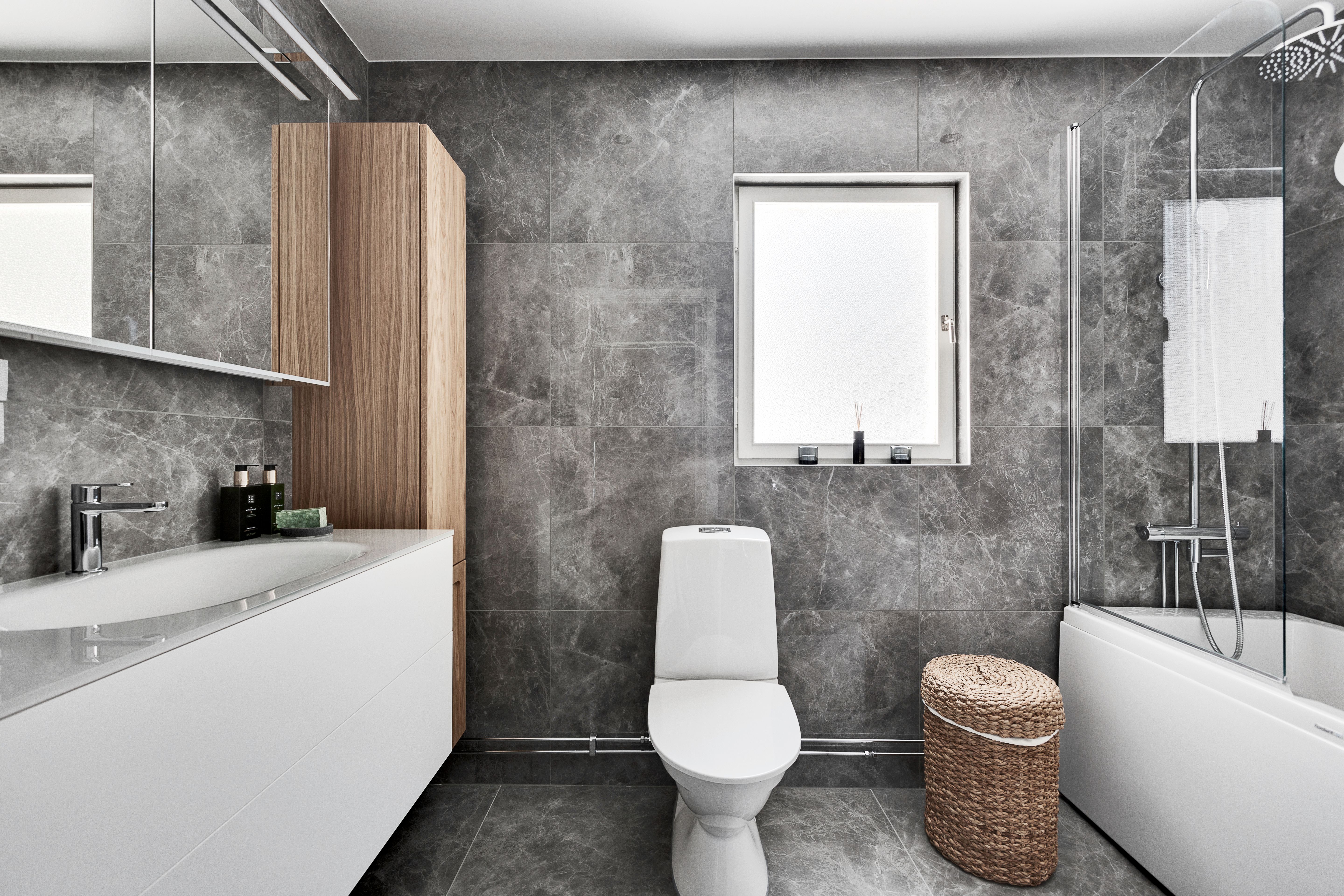 scandinavian bathroom upgrade that look expensive Contemporary bathroom interior featuring grey tiles, a bathtub, and minimalist fixtures.