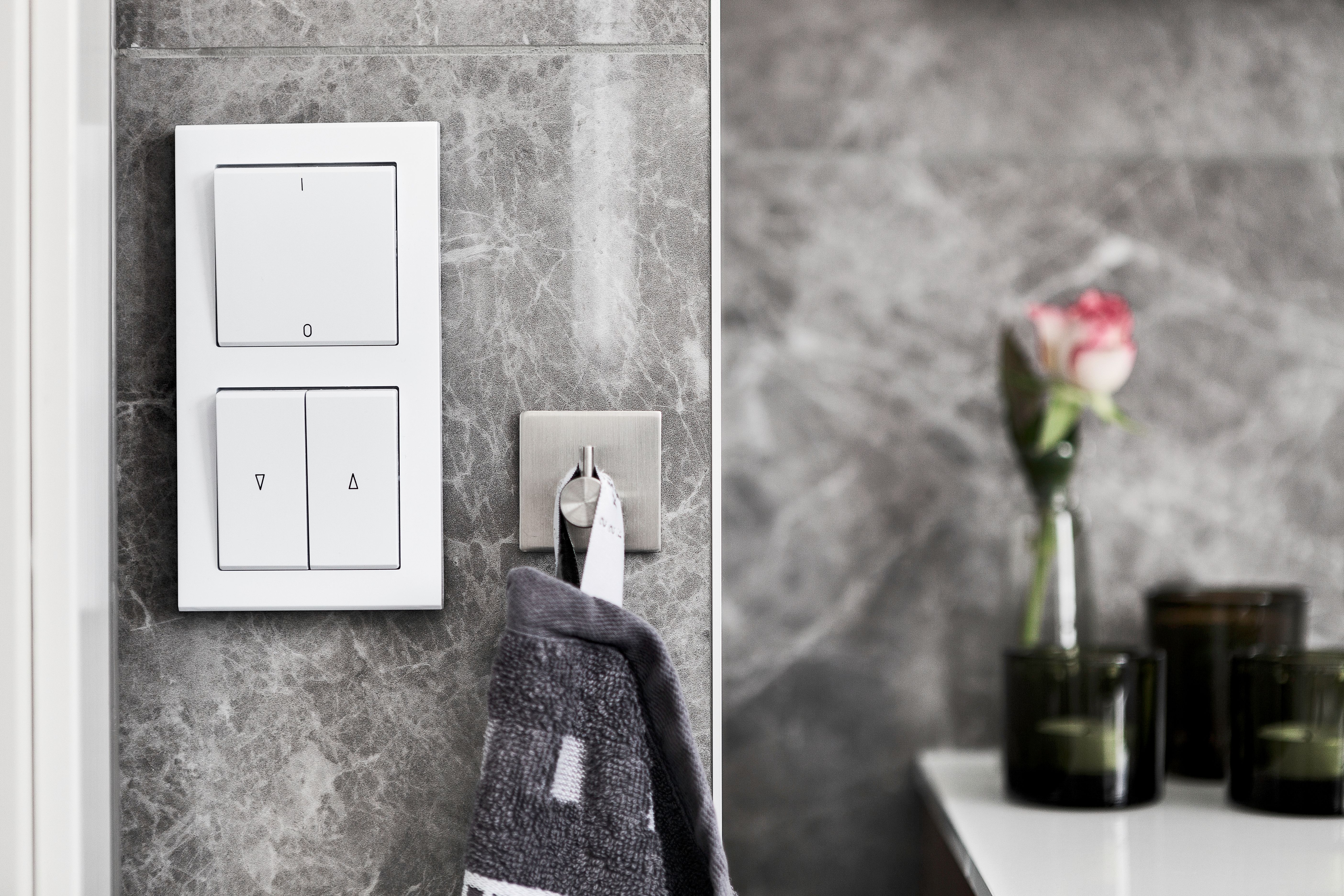Elegant bathroom featuring marble wall, switch, and minimalist decor.