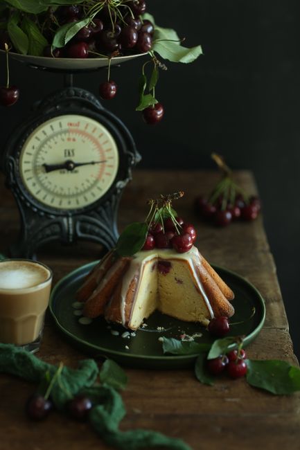 Charming presentation of cherry cake paired with vintage scale, inviting sweet indulgence.