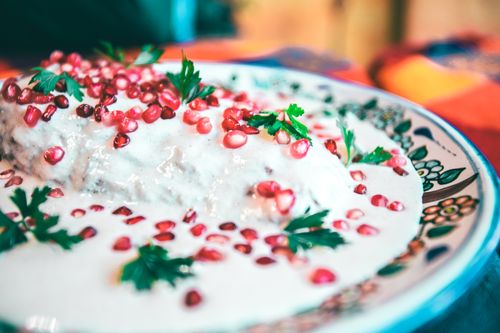 Free Close-up of traditional Mexican chiles en nogada garnished with pomegranate and parsley. Stock Photo