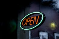 在昏暗的环境中，充满活力的霓虹灯开放标志发出光芒，营造出温馨的氛围