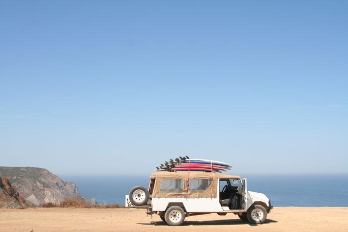 An open 4x4 parked above the beach