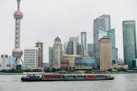 上海摩天大楼与黄浦江上货船的全景，捕捉了这座城市的现代建筑风貌