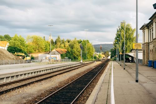 Free Tranquil summer view of Hechingen railway station with tracks and lush greenery. Stock Photo