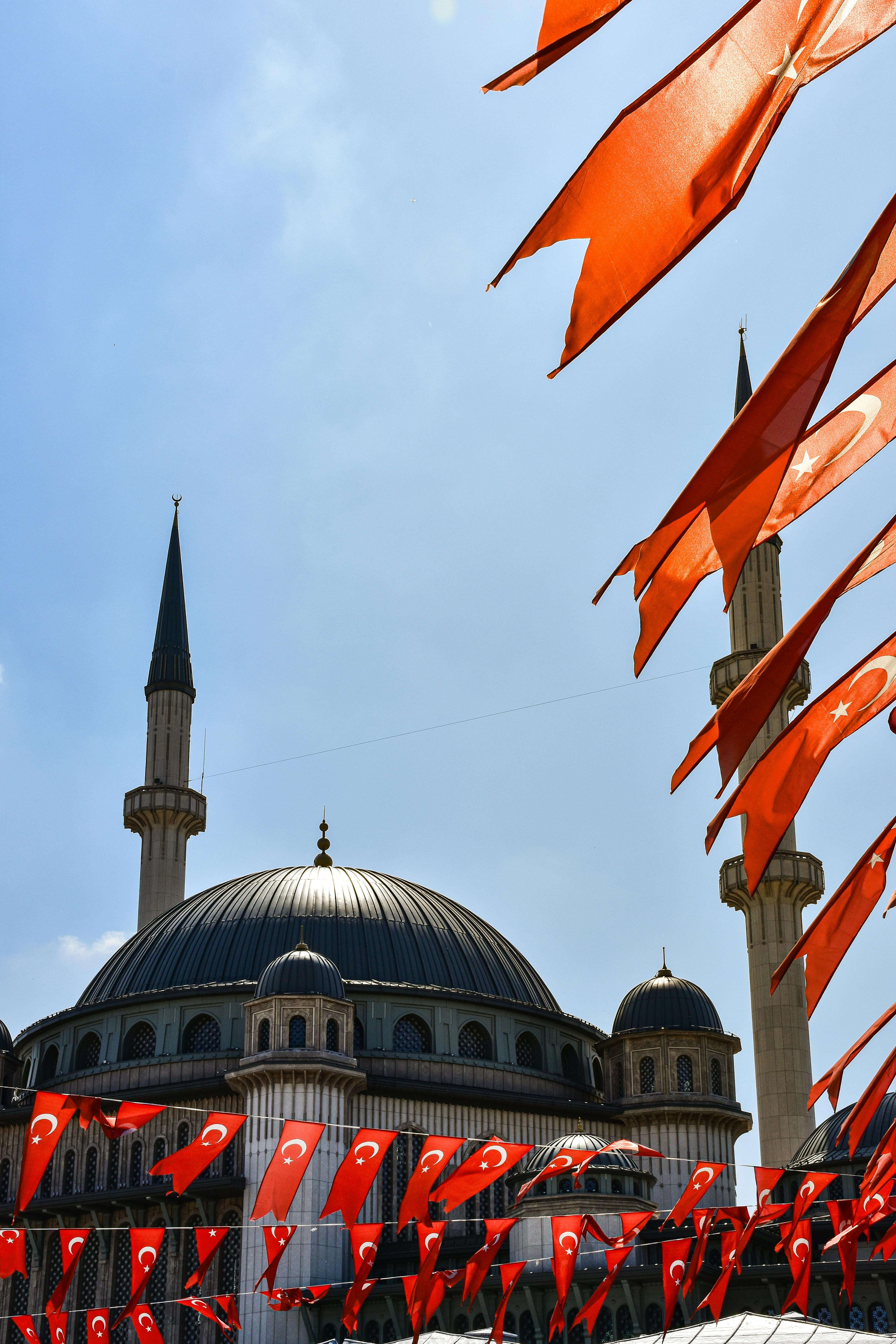 flags are flying in front of a mosque