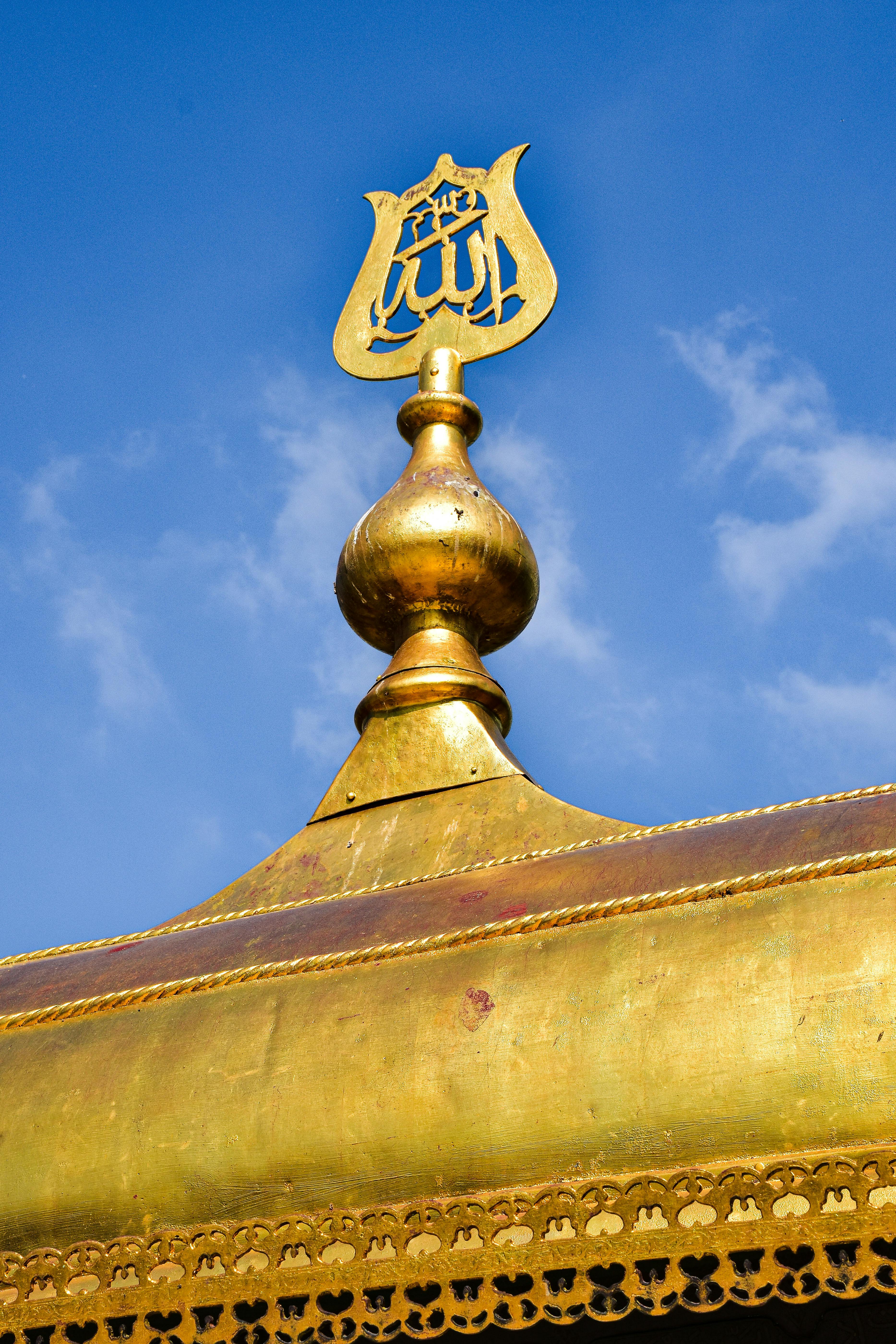 the golden roof of a building with a golden emblem