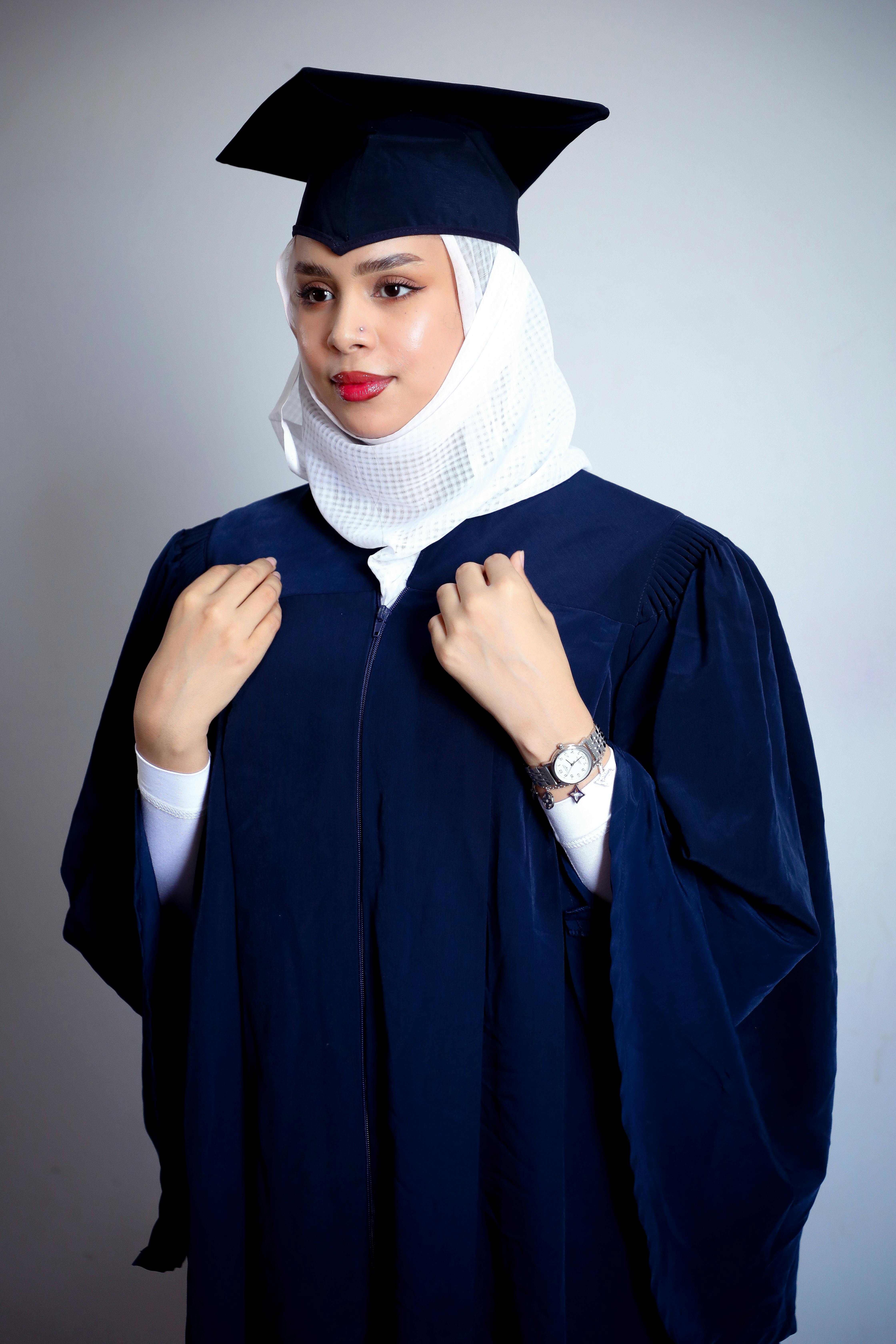 A woman in a graduation gown posing for a photo