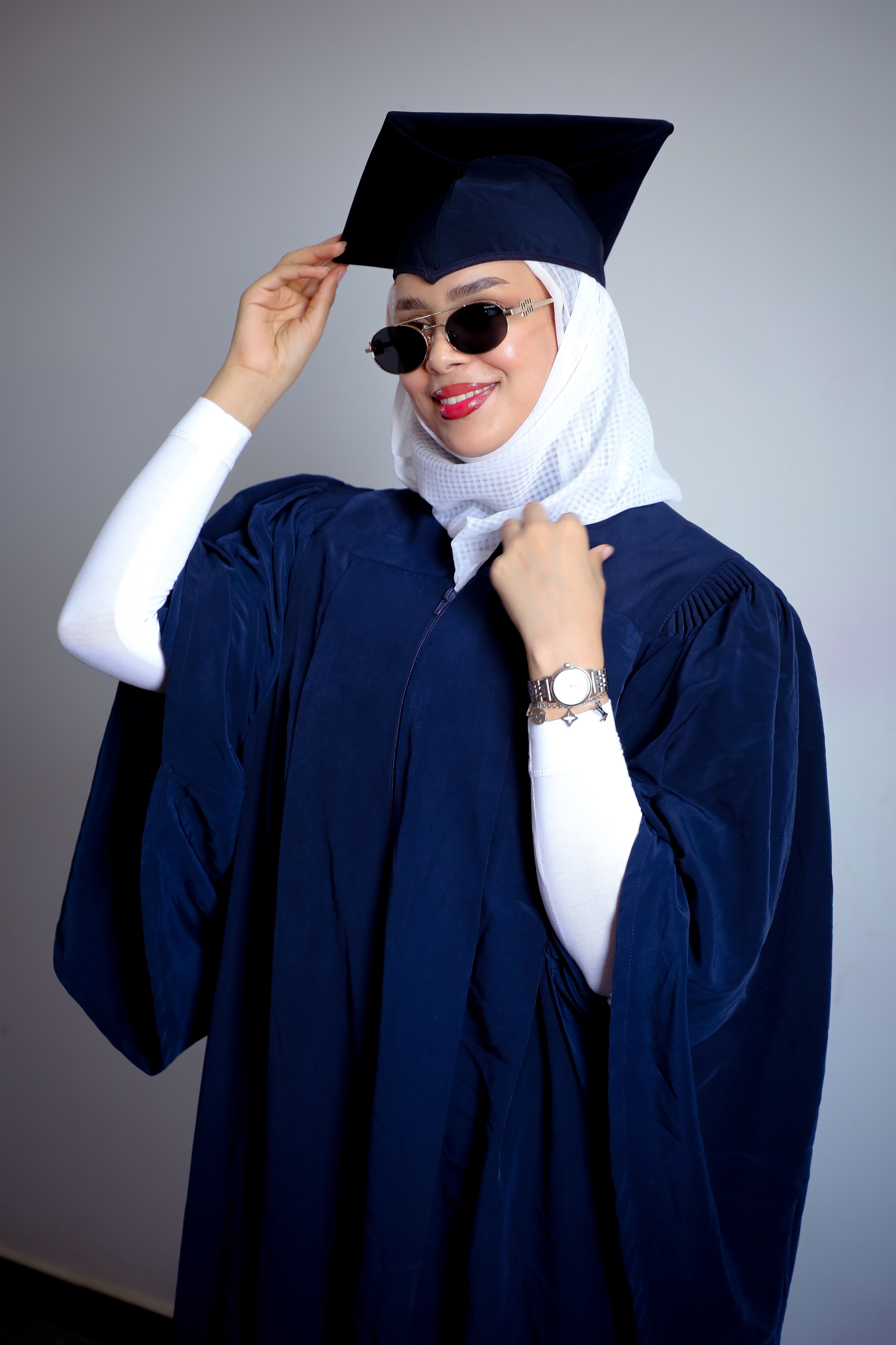 A young woman in graduation attire exuding confidence and success.