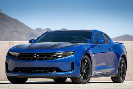 Blue sports car on asphalt against mountain backdrop in Scottsdale, AZ.