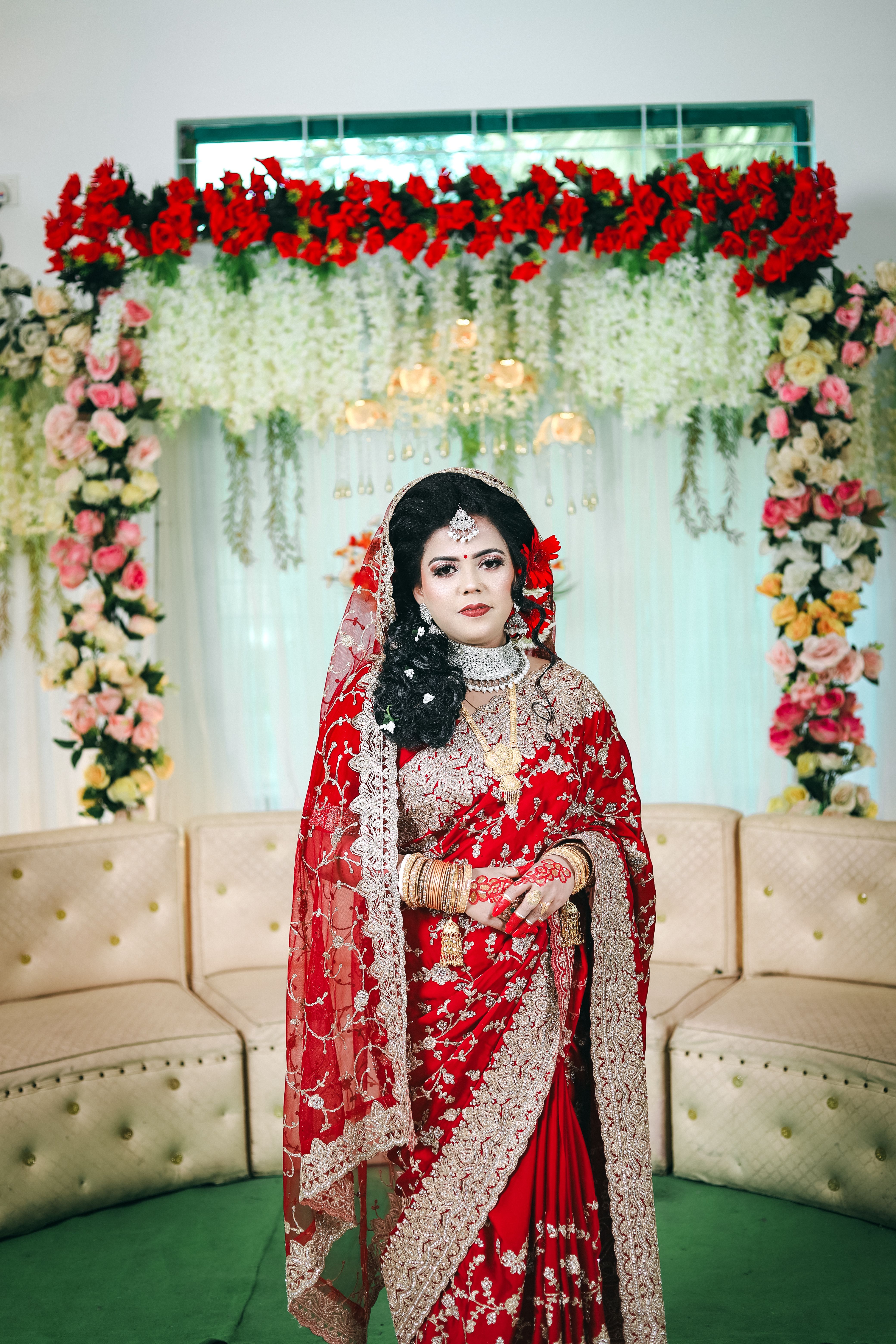A beautiful bride in red sari and gold jewelry · Free Stock Photo
