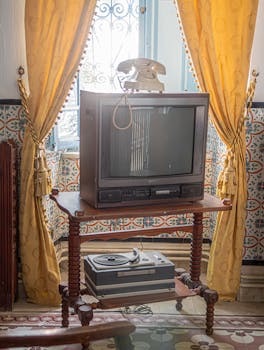 Capture of a vintage Tunisian living room with retro decor elements like TV and reel-to-reel tape recorder.