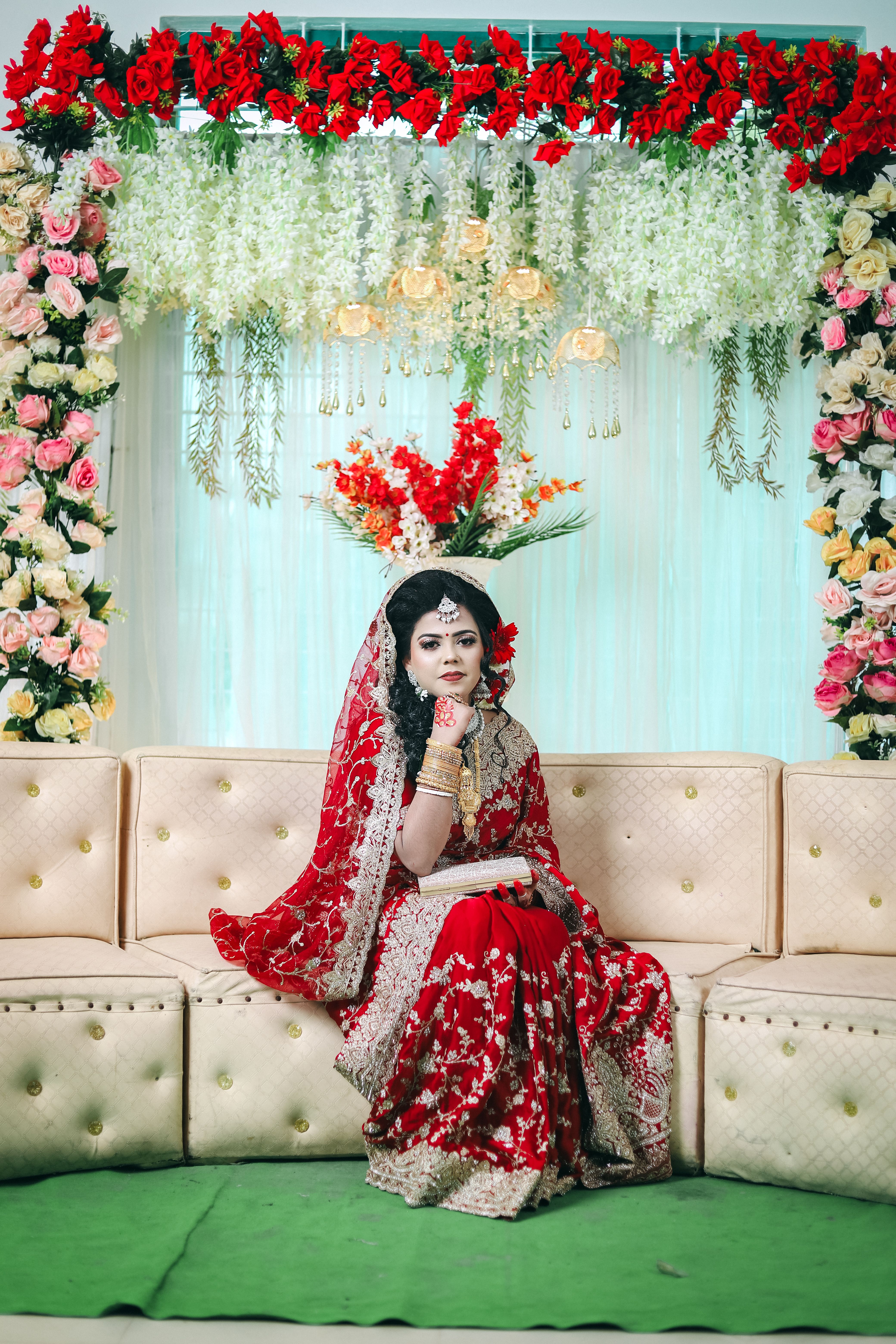 A woman in traditional attire sitting on a couch · Free Stock Photo