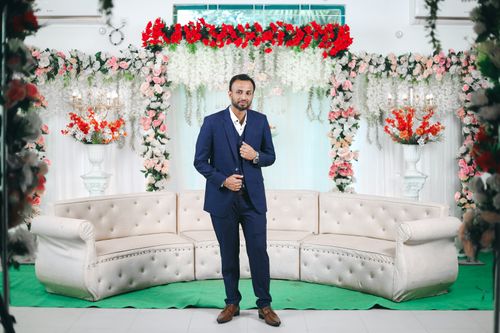 Free Man in a formal suit posing at an elegantly decorated indoor wedding setting. Stock Photo