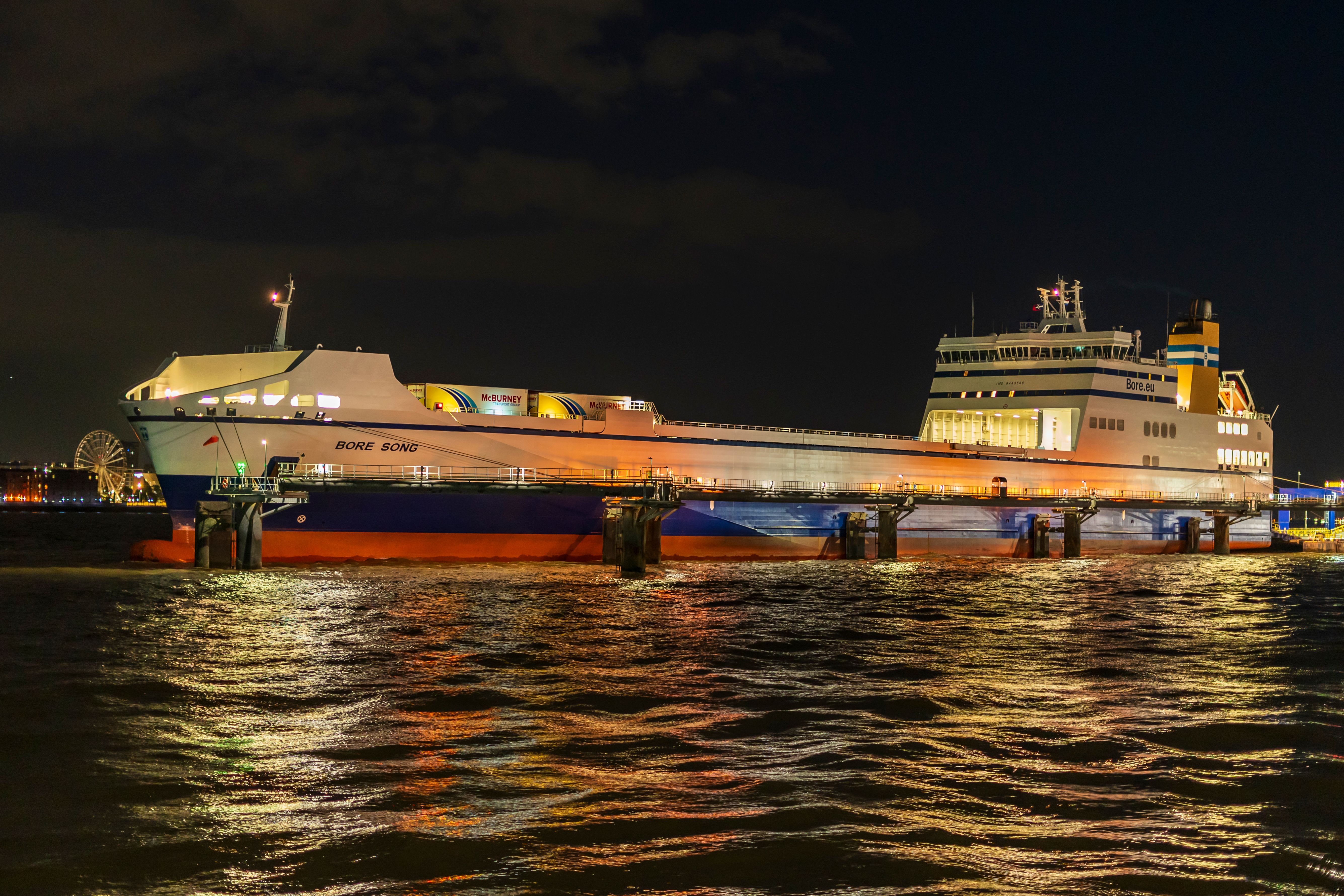 Night view of a brightly lit ferry docked in Liverpool, England.