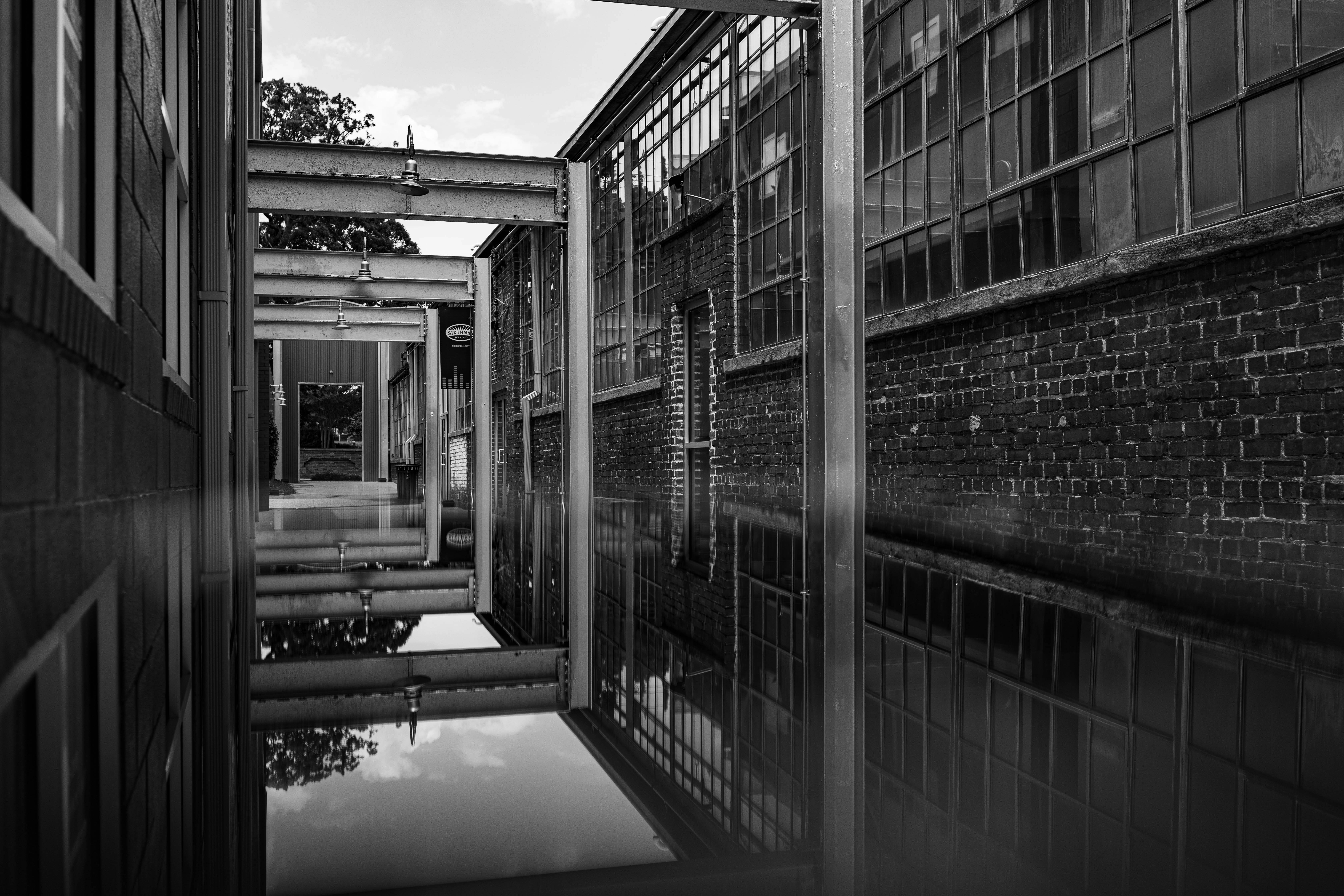 ingyenes Lenyűgöző fekete-fehér fotó egy ipari építészetről, amely vízen tükröződik. Stockfotó