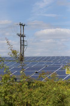 Solar panels in a rural area with power lines, illustrating renewable energy integration.