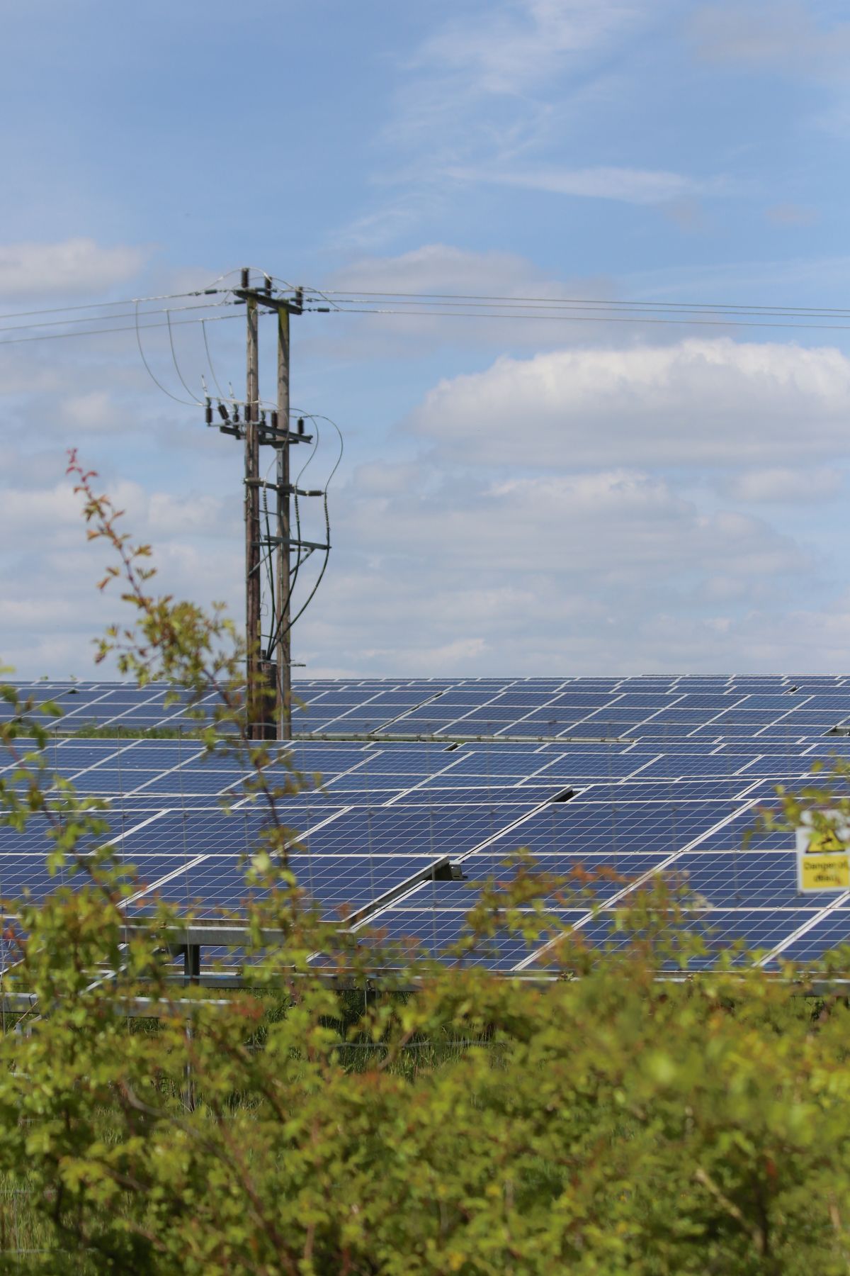 Solar panels in a rural area with power lines, an inverter-based resource whose tripping events may require PRC-030 review
