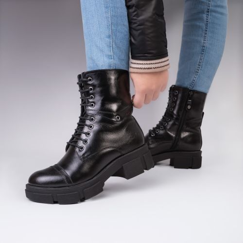 Free Close-up of a woman wearing stylish black leather boots, showcasing fashion and elegance. Stock Photo