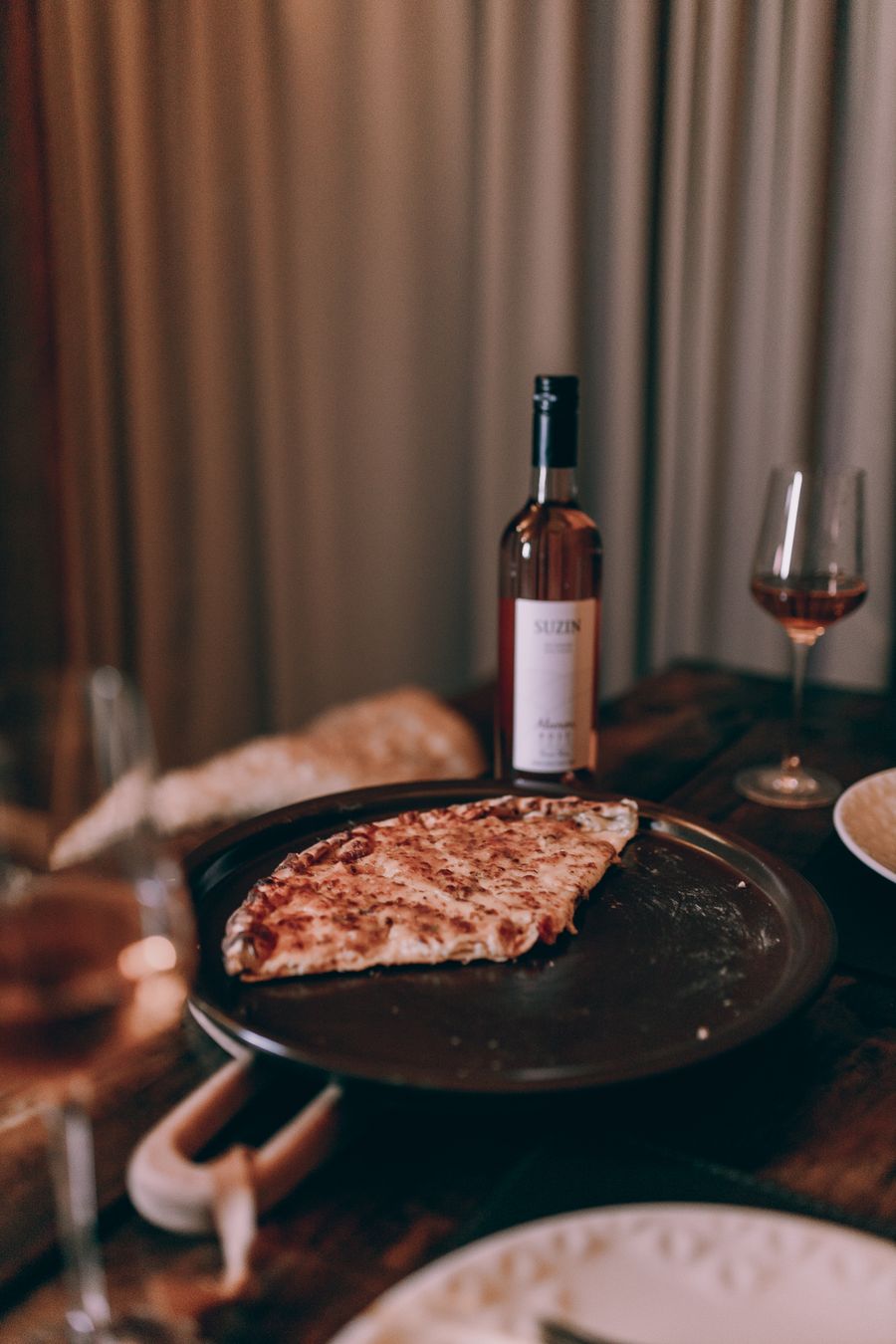 A pizza on a table with wine glasses