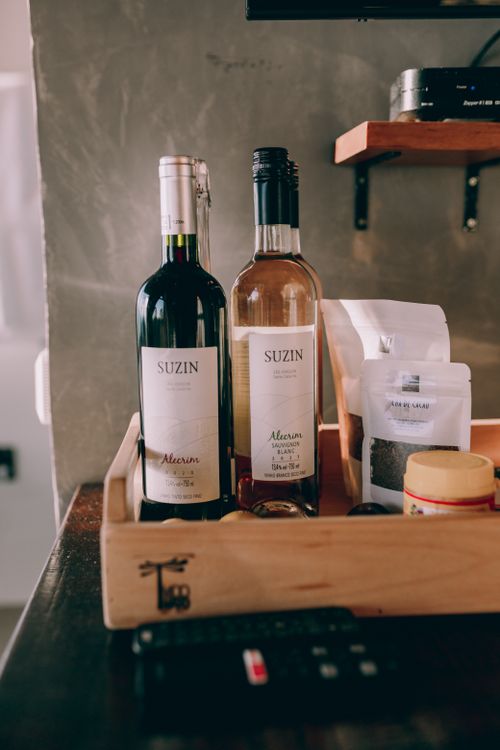Free Sophisticated display of red and white wine bottles with various accessories on a wooden tray. Stock Photo