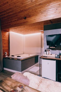 Contemporary interior with wooden ceiling and modern amenities including a hot tub and flat-screen TV.