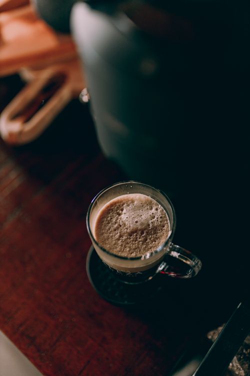 Free Warm cup of cappuccino with foamy top on a rustic wooden table in a cozy setting. Stock Photo
