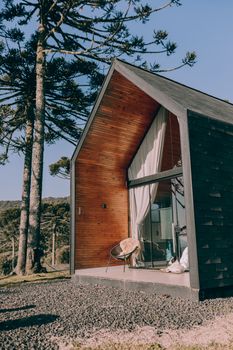 Charming small wooden cabin with large windows nestled in nature, perfect for a tranquil retreat.