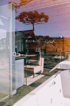 Contemporary room with a mix of indoor and outdoor elements through a glass reflection.