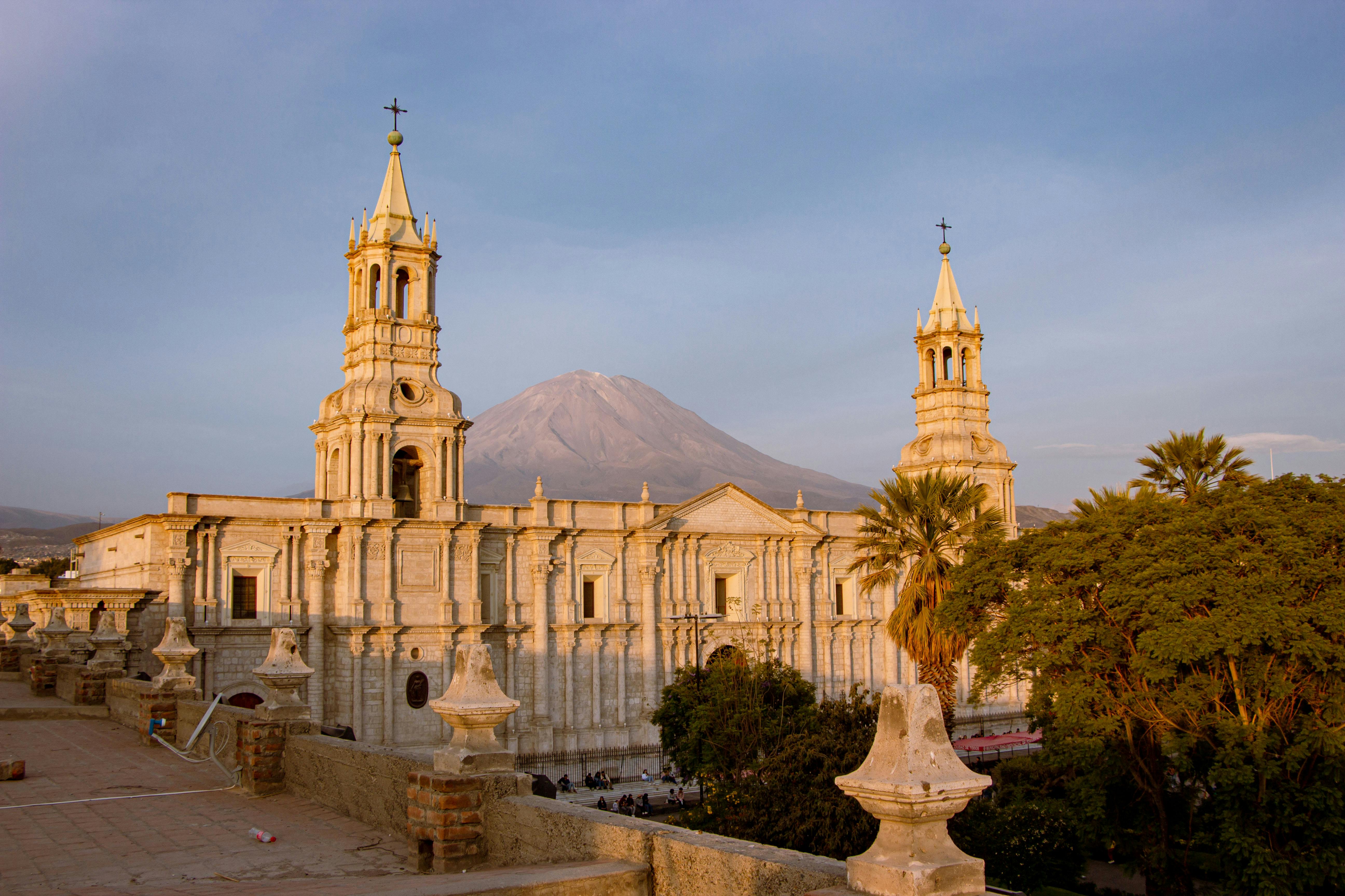 View of the Arequipa Cathedral in Peru with El Misti volcano in the backdrop during sunset.